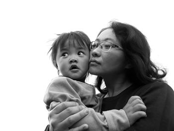 Mother with daughter against clear sky