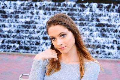 Portrait of beautiful woman against wall