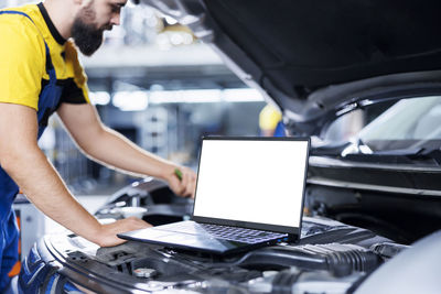 Midsection of man using laptop