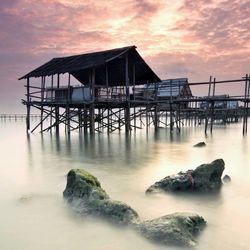 Pier on sea against sky during sunset