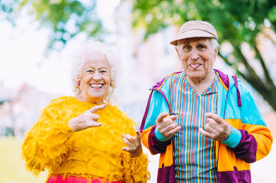 Portrait of smiling friends standing against trees