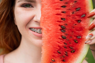 Close-up of young woman holding fruit