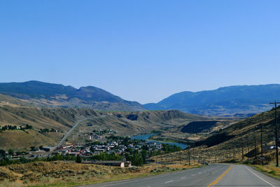 Road amidst landscape against clear blue sky