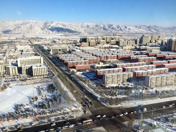 Aerial view of buildings against sky on sunny day in city