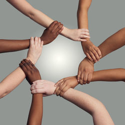 Low section of woman holding hands against white background