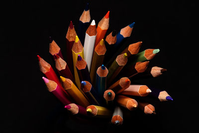High angle view of colored pencils against black background