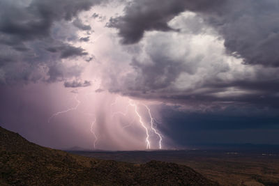 Lightning bolts illuminate a strong thunderstorm with heavy rain over wickenburg, arizona