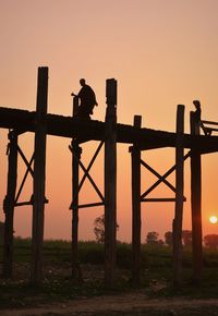 Silhouette man standing on field against clear sky during sunset