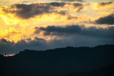 Low angle view of silhouette mountain against dramatic sky