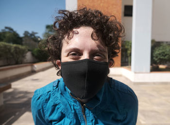 Brazilian curly hair woman using mask on a sunny day.