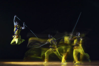 Blurred motion of men dancing on stage