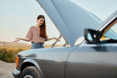 Side view of woman holding car