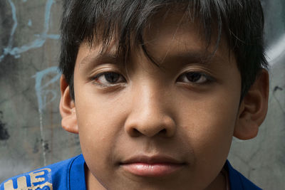 Close-up portrait of boy against wall