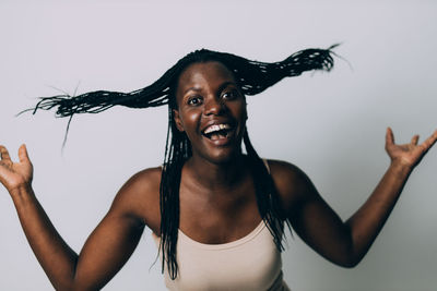 Portrait of happy young woman against gray background