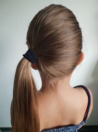 Rear view of woman with hair against wall