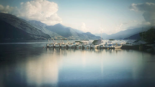 Sailboats moored in lake against sky