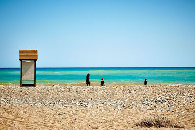 Scenic view of beach against blue sky