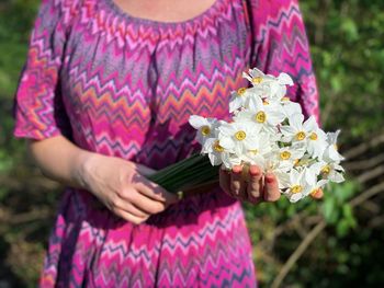 Midsection of woman holding flowers