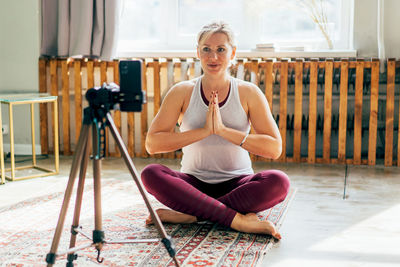 Portrait of woman sitting on wooden floor