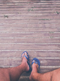 Low section of man standing on boardwalk