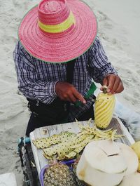 High angle view of man cutting pineapple