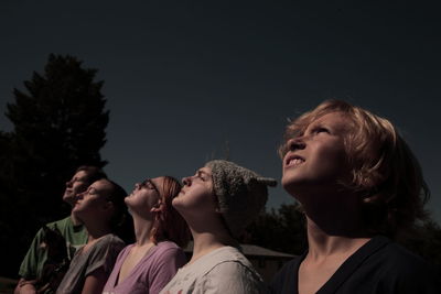 Low angle view of young woman against sky