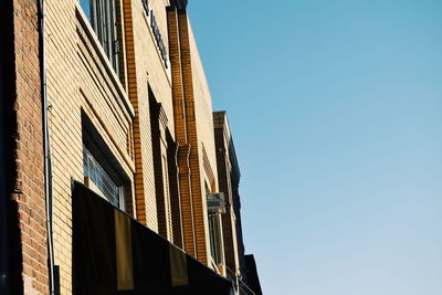 Low angle view of office building against blue sky