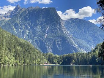 Scenic view of lake by mountains against sky