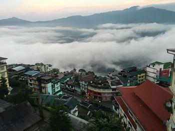 High angle view of town in foggy weather during sunset