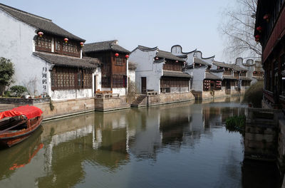 Canal amidst houses against sky