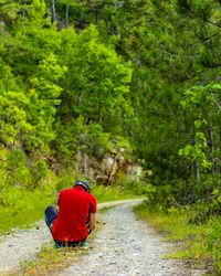 Rear view of a woman sitting on road