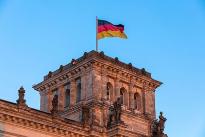 Low angle view of flag against blue sky