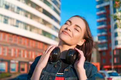 Young energetic cheerful caucasian woman wearing headphones. dressed in a denim