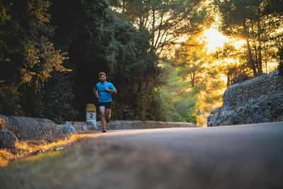 Man running on rock by trees