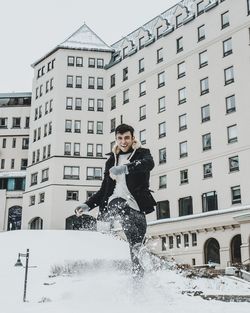 Portrait of smiling man kicking snow