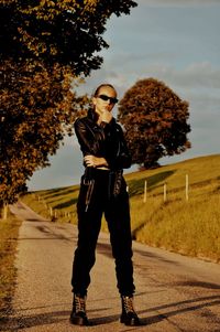Full length portrait of young man standing on footpath