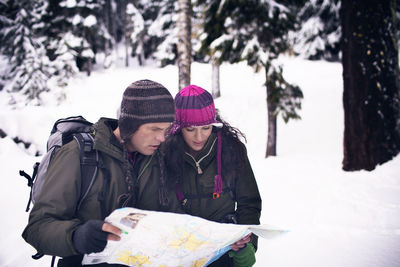 Couple looking at map in forest