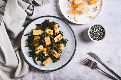 Vegetarian fried tofu and seaweed salad on a plate on the table top view