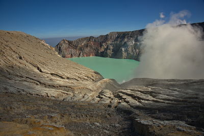Scenic view of ijen volcano, indonesia with clouds above the crater