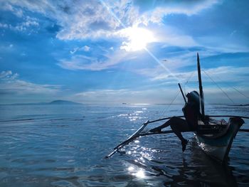 Silhouette of woman sitting on boat against sky