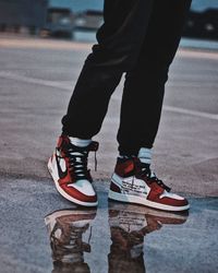 Low section of man walking by puddle on road