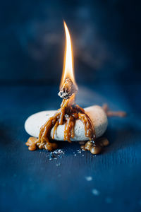 Close-up of burning candle on table