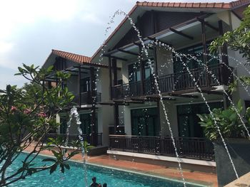 View of swimming pool by building against sky