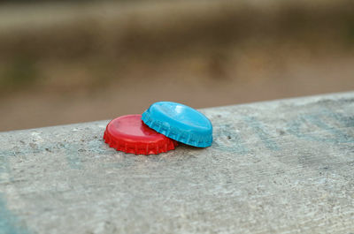 Two colored bottle caps on the wall in focus on foreground