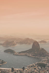 High angle view of city by sea against sky