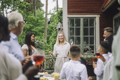 Smiling woman welcoming family members at party