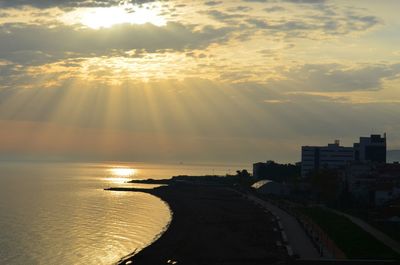 Sun shining through clouds over sea