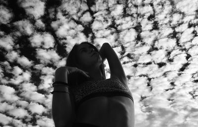 Low angle portrait of woman against sky