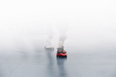 Low section of people skating on ice rink