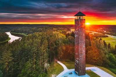 View of tower against forest during sunset